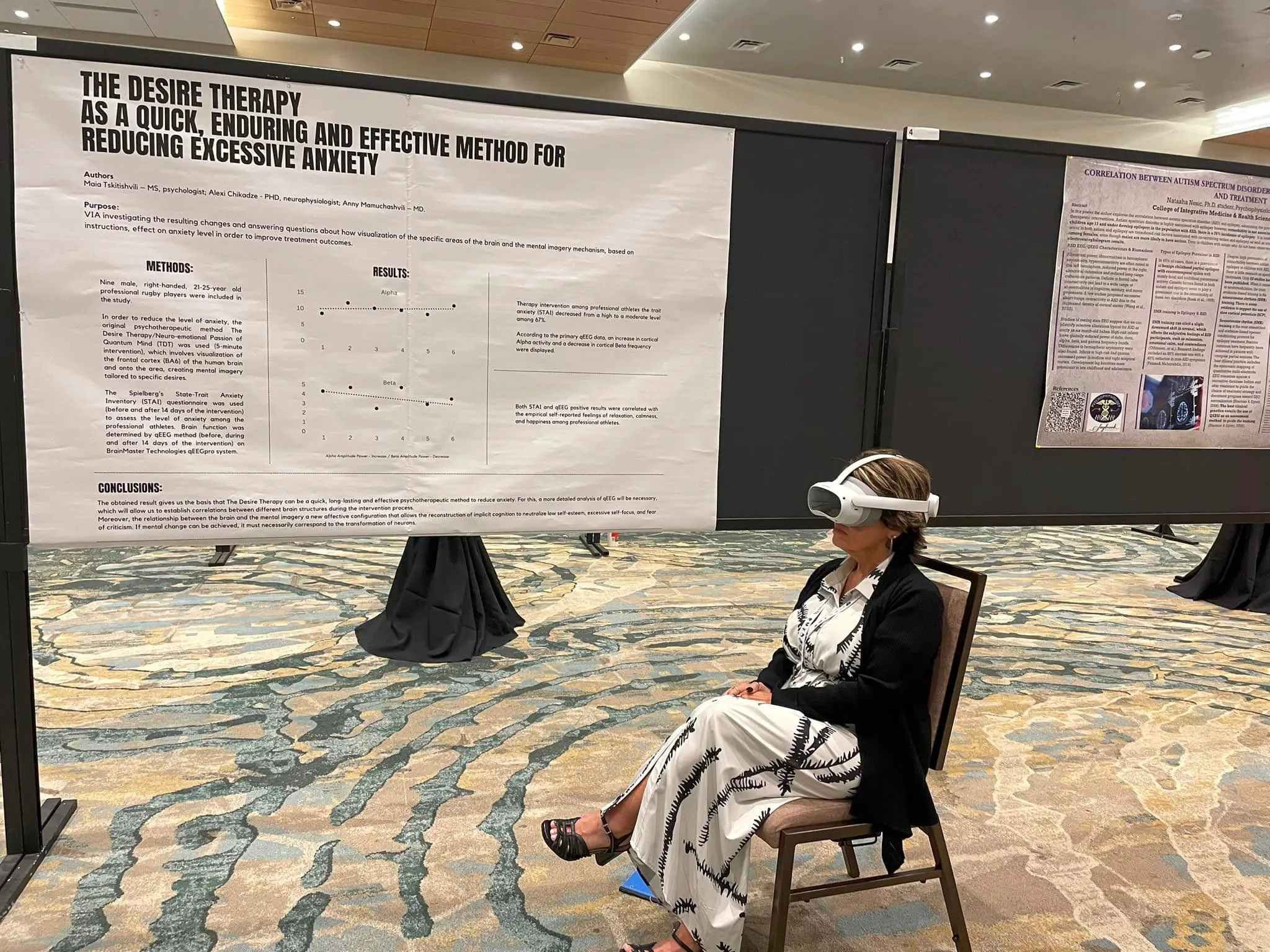 Person wearing a VR headset, seated in front of the TDT conference poster